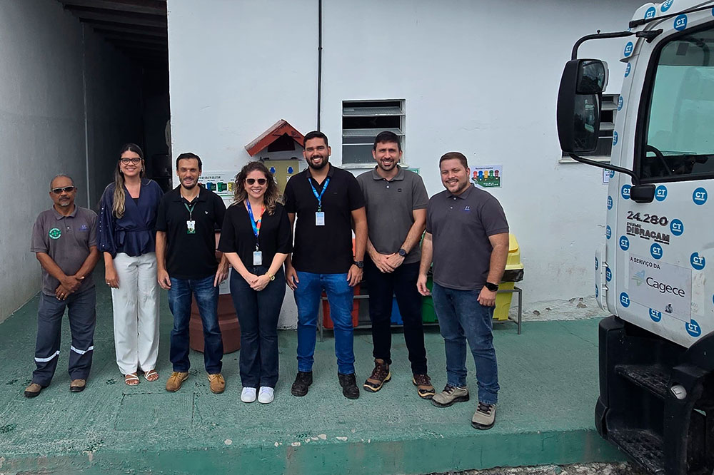 Equipe da Cacege comemoram a Certificação Lixo Zero, estão em frente de uma área de reciclagem. Aparecem 5 homens e 2 mulheres. Um do lado do outro.