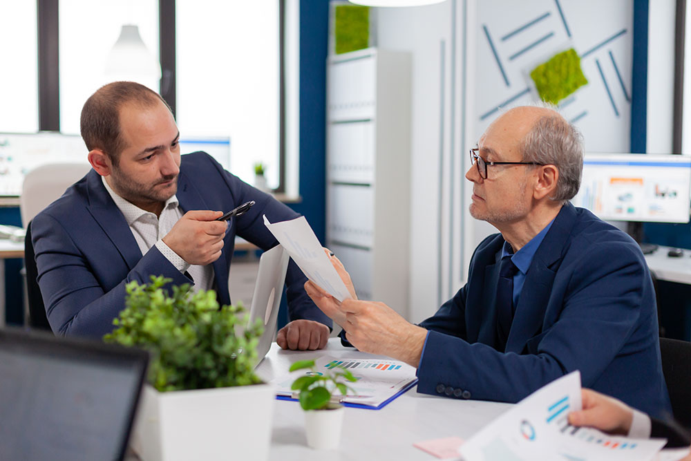 Dois homens de terno azul, discutem sobre o diferencial competitivo no mercado e para investidores na Certificação Lixo Zero